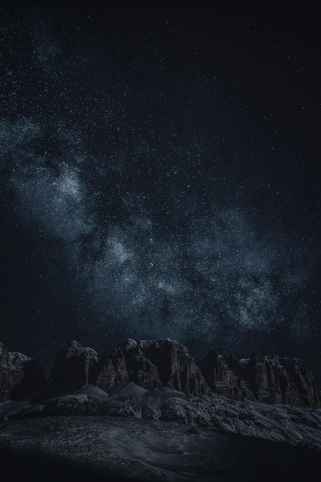 Stunning view of the starry night sky with rocky mountain silhouettes.